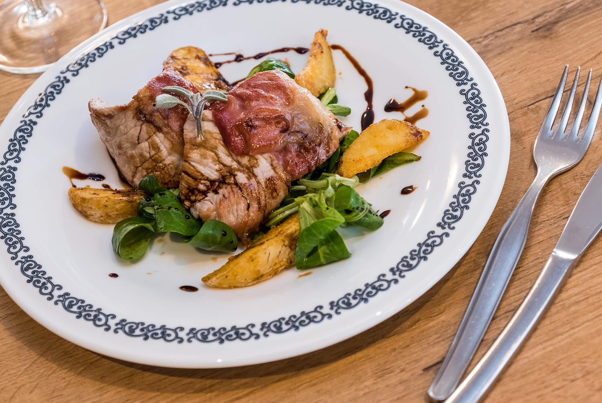 Plate with meat, baked potatoes and lamb's lettuce - Schirmerhof