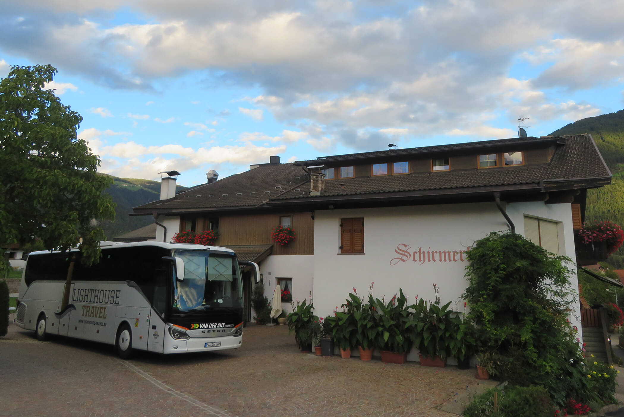 The Schirmerhof from the outside with a coach in front of it