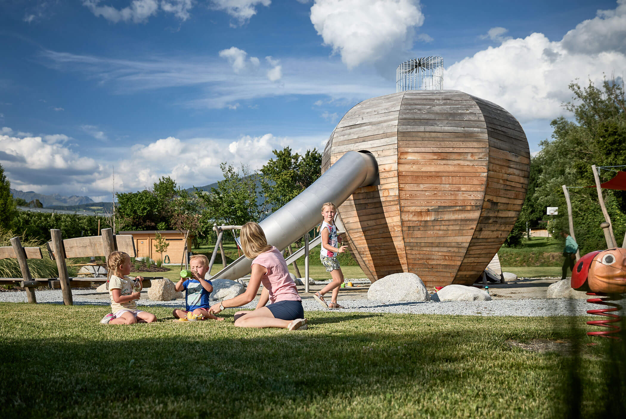 A woman with three children on a large playground - Schirmerhof