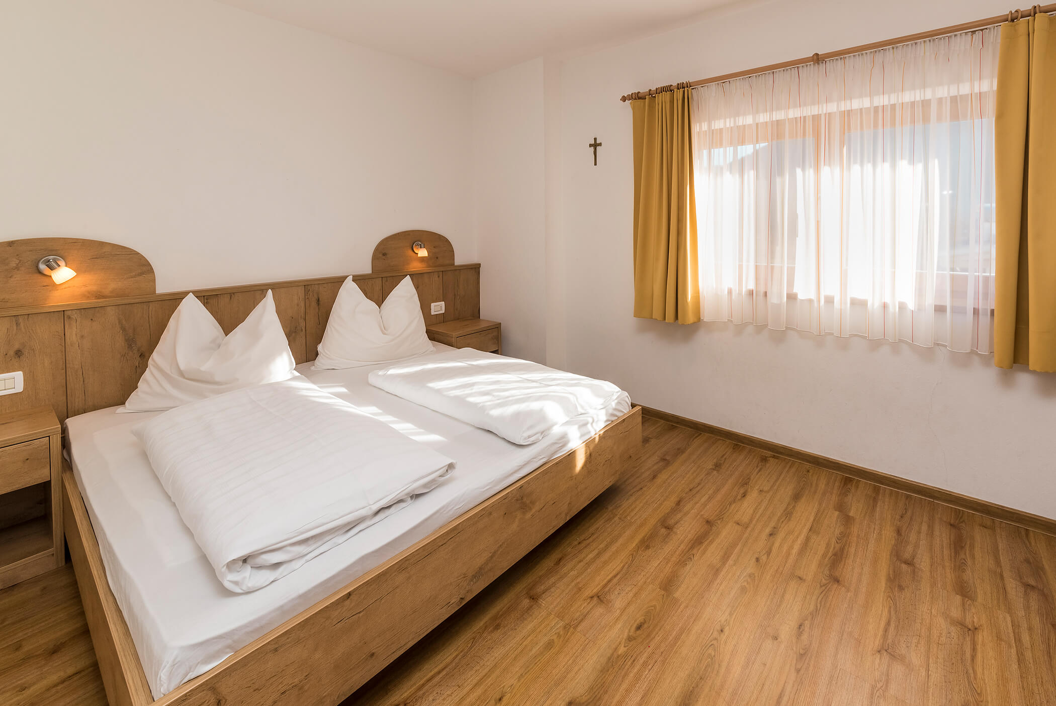 Bedroom with double bed and large window - Schirmerhof