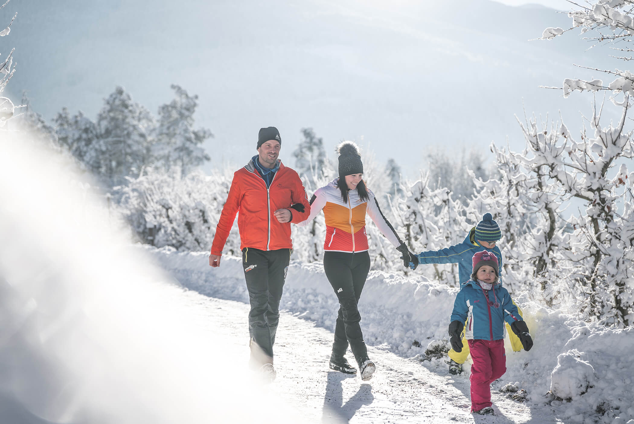 A family walks through a snowy landscape - Schirmerhof
